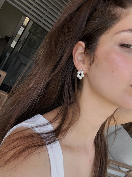 a woman with a flower shaped pearls earring