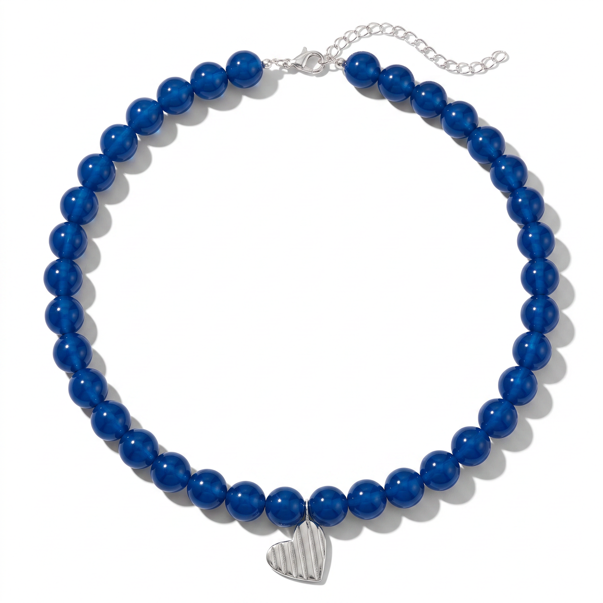 A beaded necklace featuring glossy royal blue beads and a silver-toned heart-shaped charm, displayed on a clean white background.